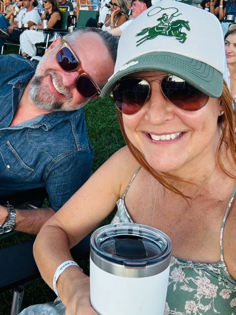 Two CI Web Group teammates outdoors at a sunny gathering, smiling in sunglasses