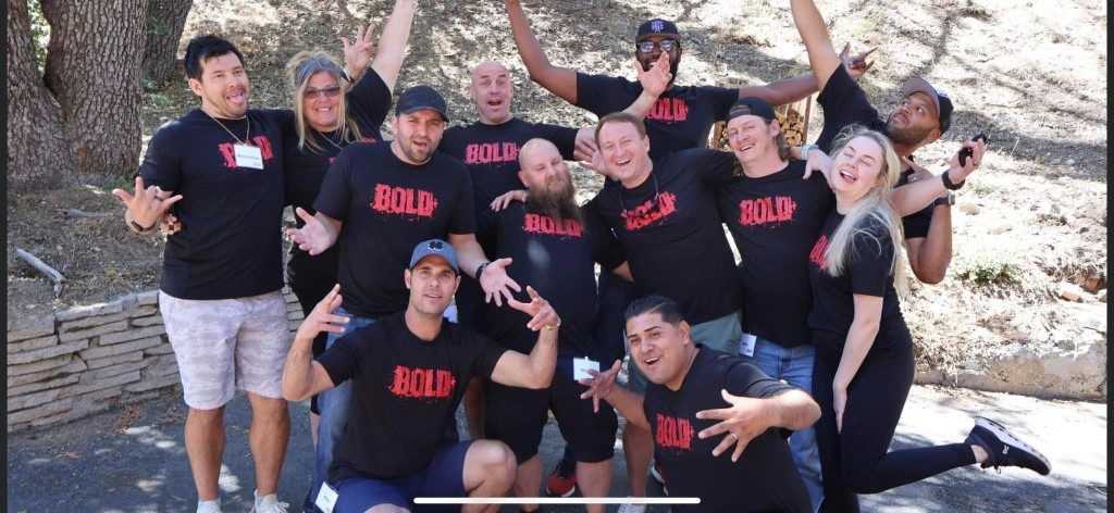 BOLD graduates in black BOLD shirts celebrating together
