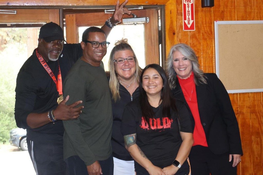 BOLD graduates in black BOLD shirts at the venue doorway