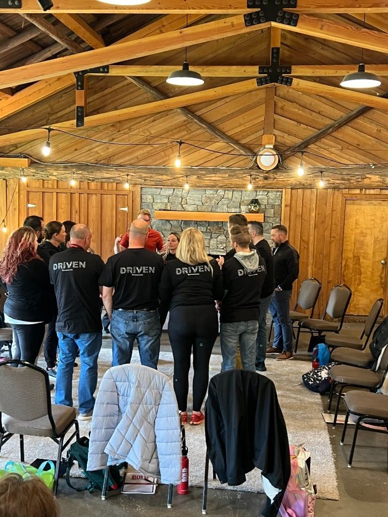 BOLD participants in DRIVEN shirts gathered inside the training room