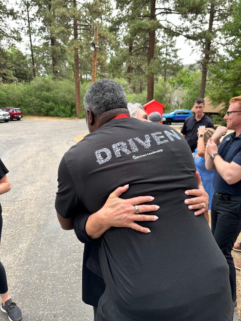 BOLD participants hugging with DRIVEN shirt visible on the back