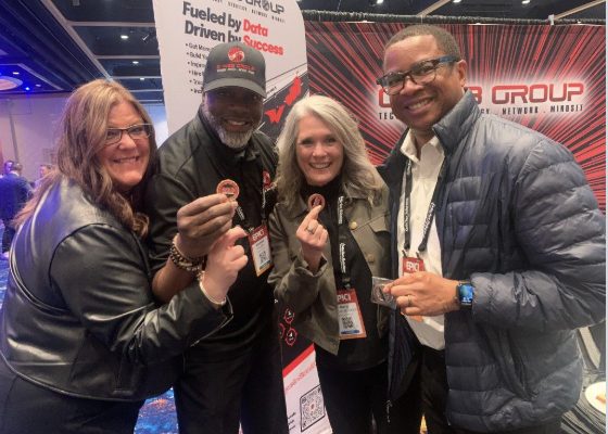 CI Web Group leaders holding BOLD coins at an event booth