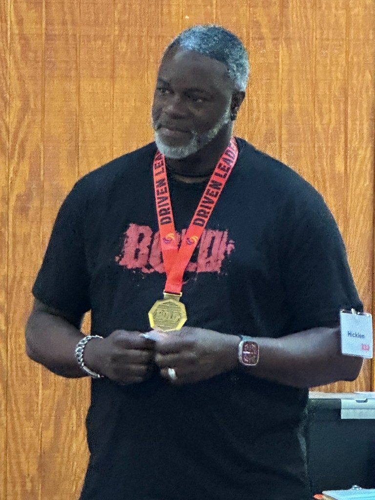 BOLD graduate in black BOLD shirt with medal