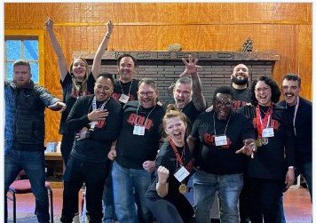 BOLD graduates celebrating indoors with medals