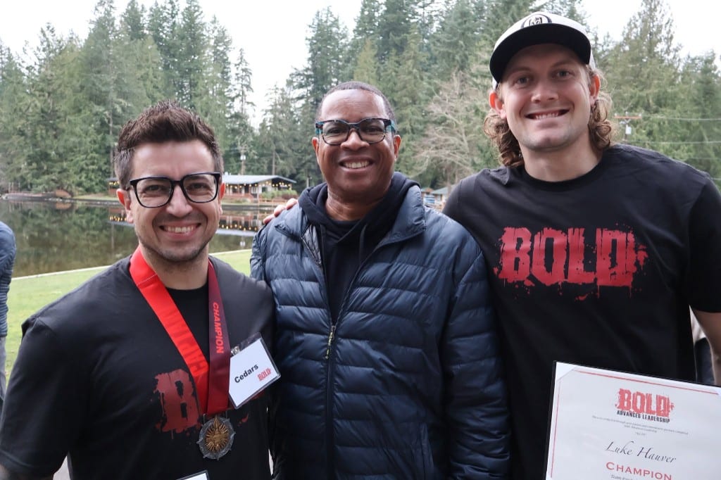 BOLD Advanced Leadership champions holding a certificate and medal by a lake
