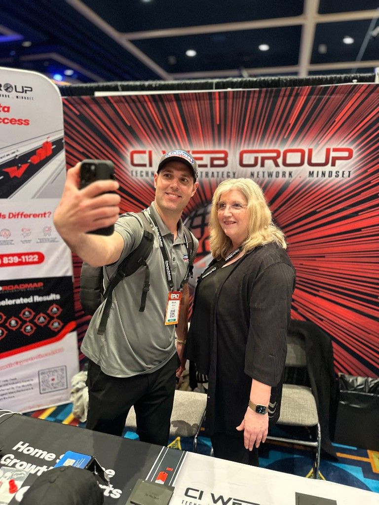 CI Web Group team members taking a selfie at their branded trade-show booth