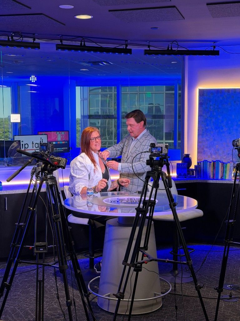 A CI Web Group interview being filmed on a blue-lit studio set