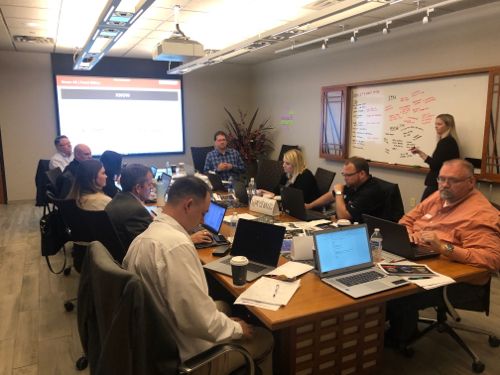 CI Web Group team members working on laptops around a boardroom table