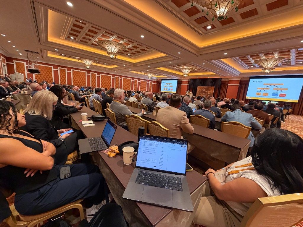 CI Web Group team members working on laptops from the rows of a conference ballroom
