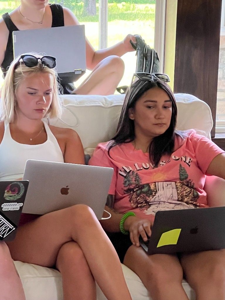 CI Web Group team members working on laptops together on a couch