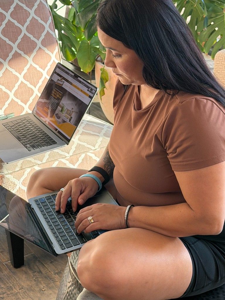 A CI Web Group team member working cross-legged with a laptop