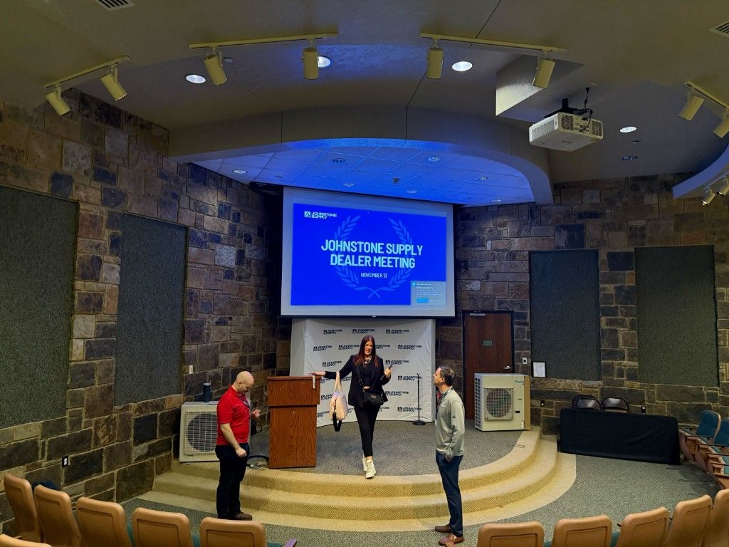 A CI Web Group presenter on stage at a Johnstone Supply dealer meeting