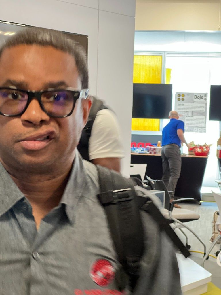 A CI Web Group team member with a backpack at an office work space