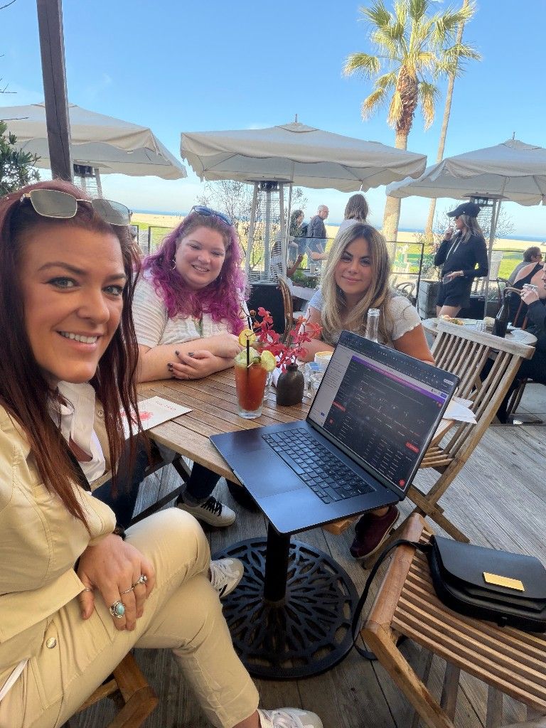 CI Web Group team members working on laptops at an outdoor cafe
