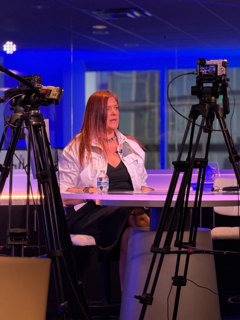 A CI Web Group team member framed between two studio cameras during a recording