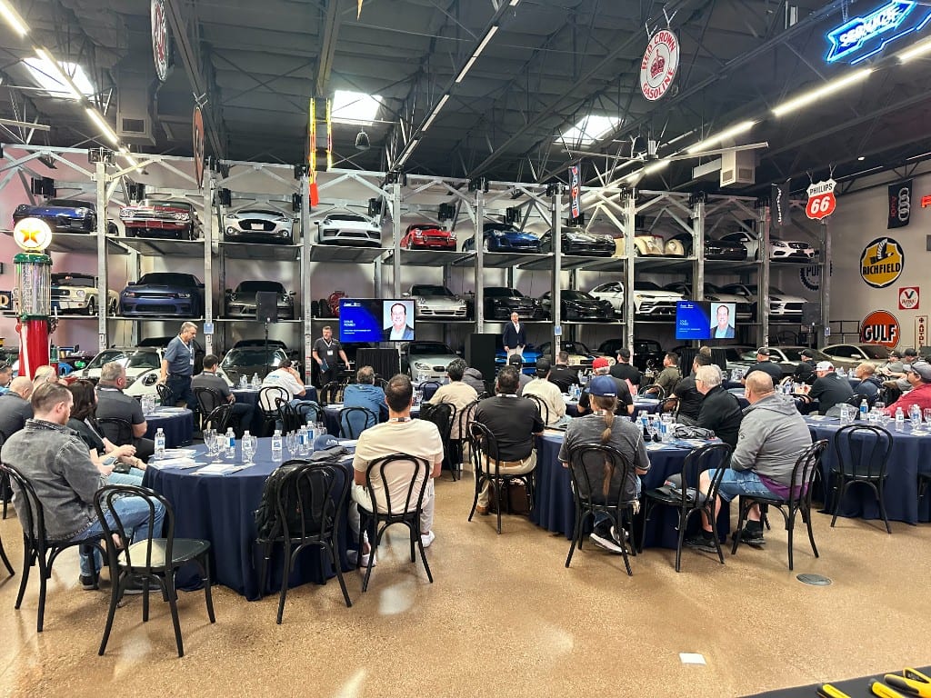 Contractors seated for a CI Web Group session at a classic-car collection venue