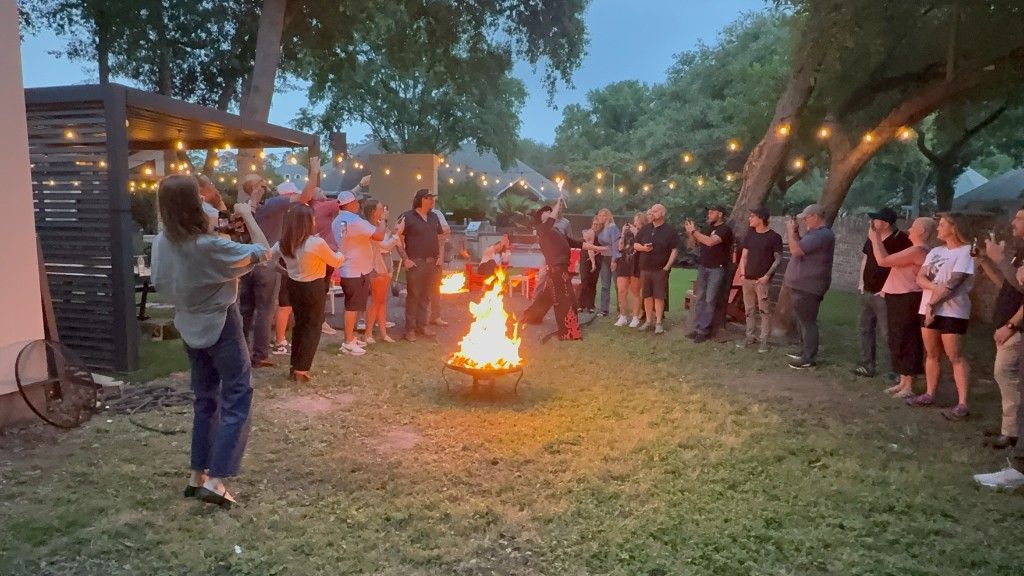 Trades operators gathered around a bonfire at an evening community event