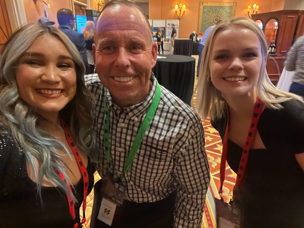 CI Web Group team members with a client at a trades-industry conference