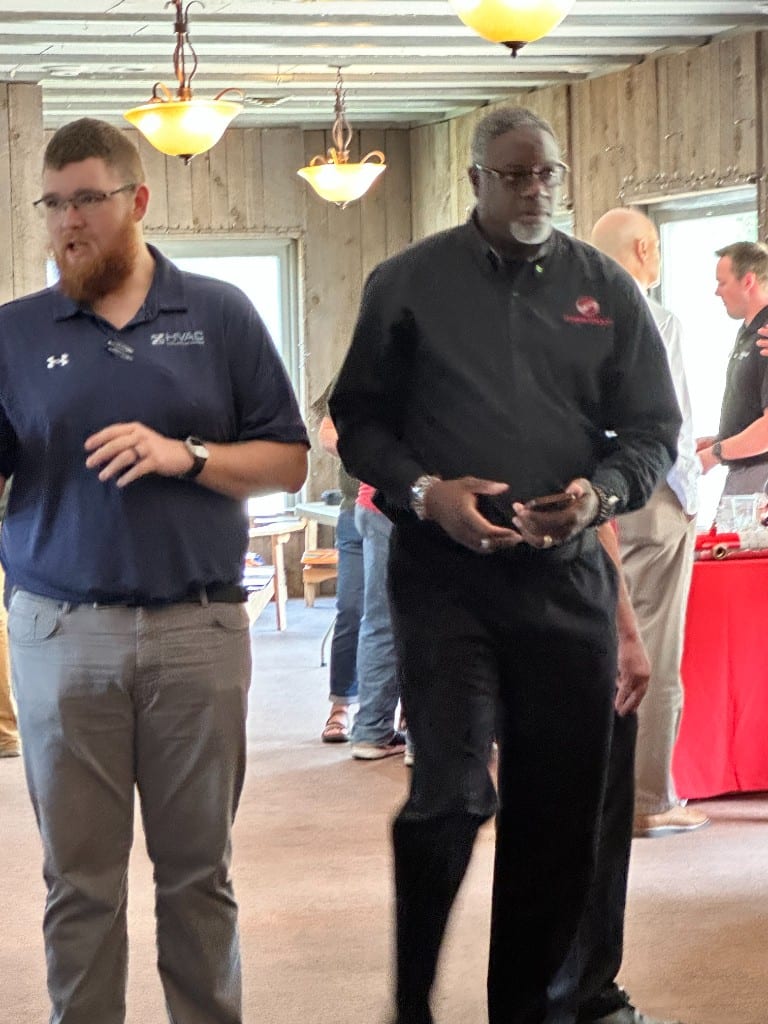 A CI Web Group team member talking with a contractor at a dealer event