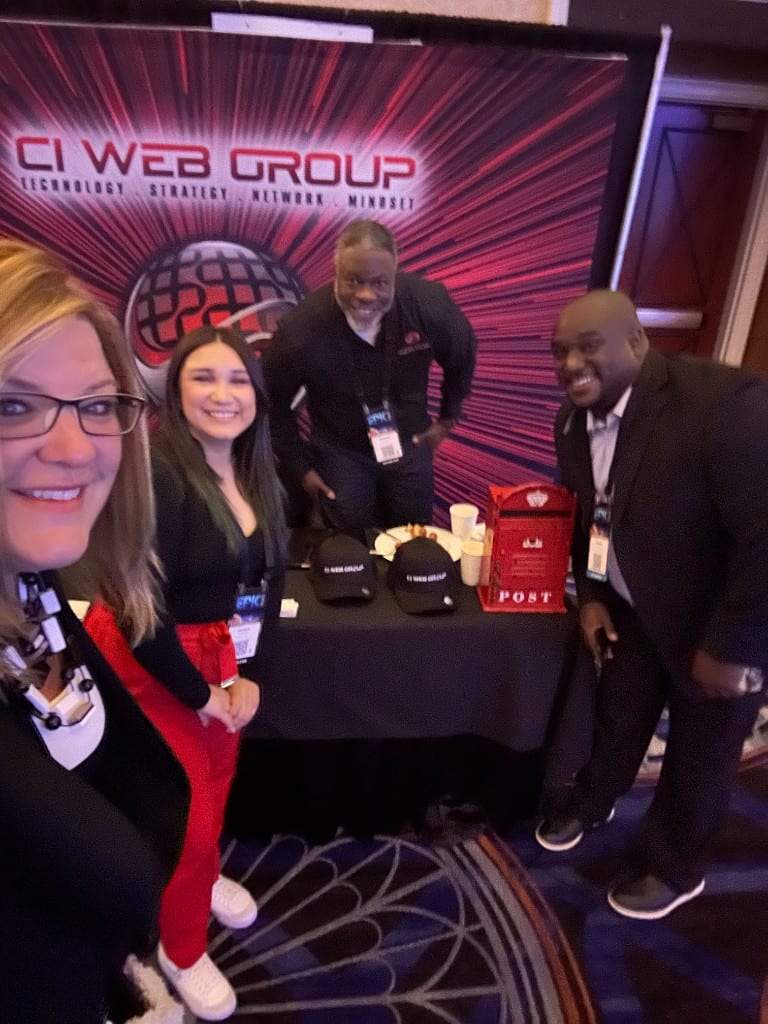CI Web Group team at their EPIC conference booth with a branded post box