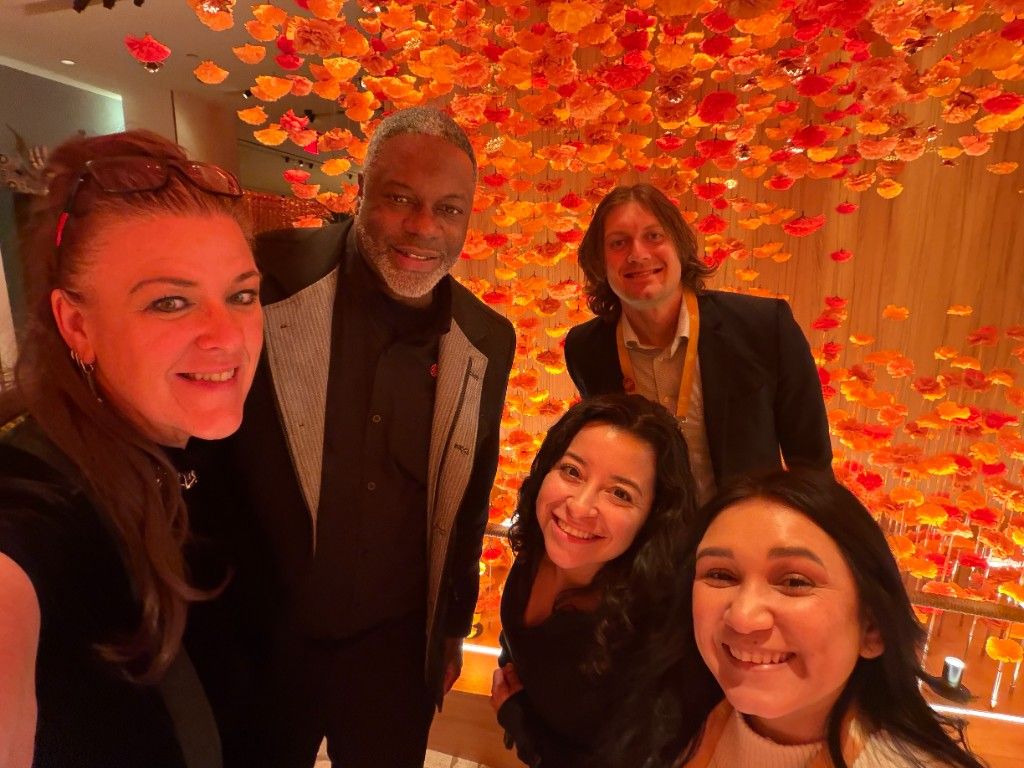 CI Web Group team members in front of a red rose wall at an evening event