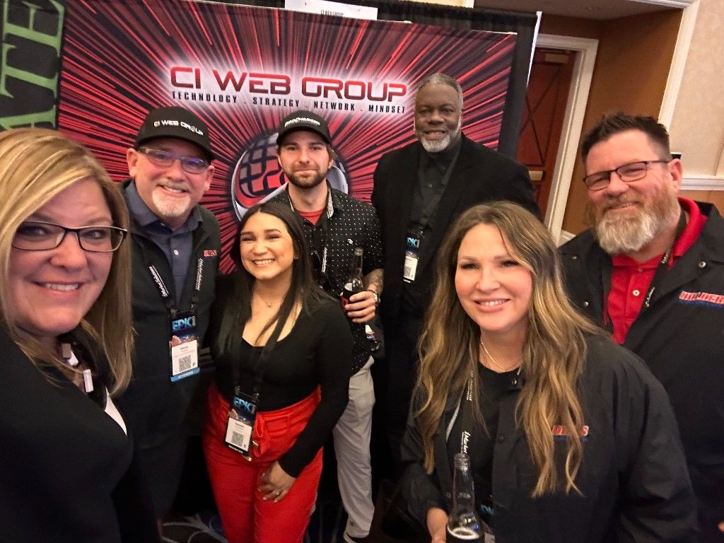 CI Web Group team in front of their branded banner at an event