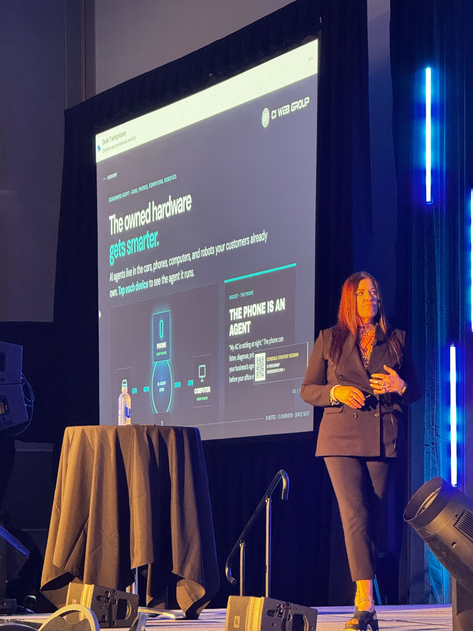 Jennifer Bagley on stage in front of a slide about AI agents on the devices customers already own