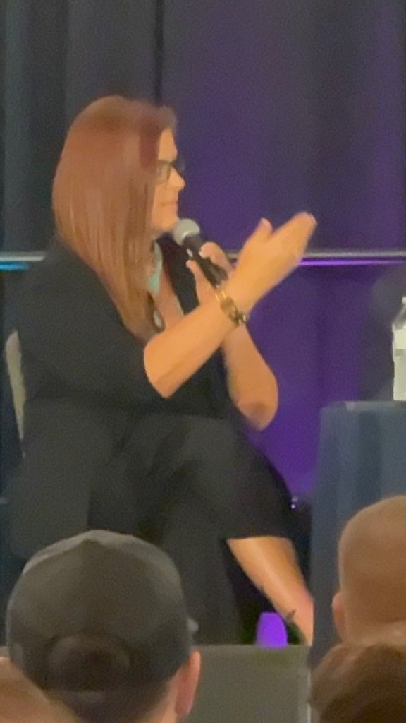 Jennifer Bagley of CI Web Group speaking with a microphone on stage